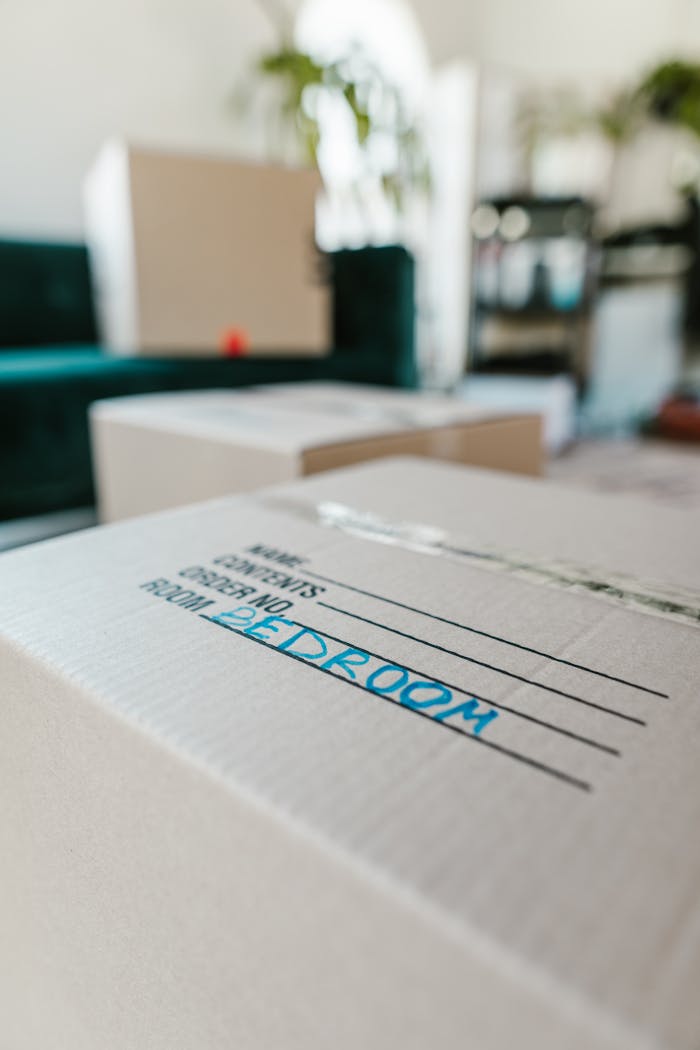 Packed cardboard box labeled Bedroom indoors, ready for moving.
